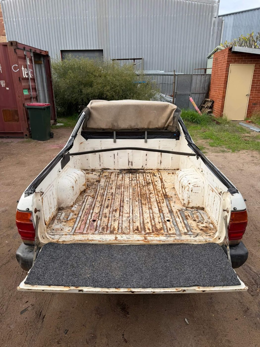 Older ute tub with heavy scaling rust through the floor ribs, wheel tubs and tailgate before blasting