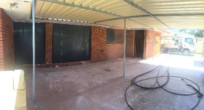 Brick alfresco masked with plastic sheeting ahead of blasting