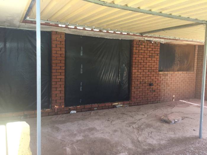 Painted brick alfresco wall masked and ready for paint removal in Perth