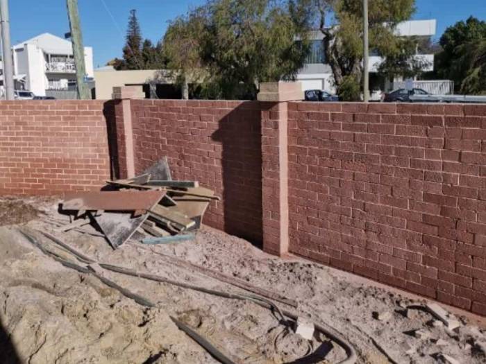 The same boundary wall stripped back to red face brick