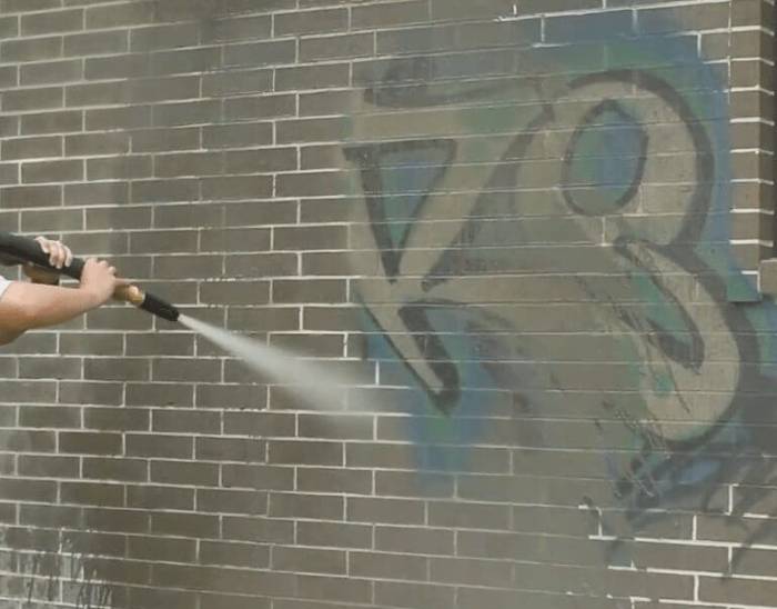 Graffiti piece on a rail carriage side before dustless blasting removal
