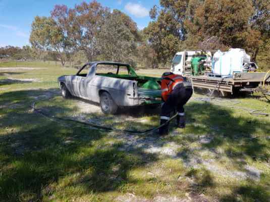 Mobile car stripping service blasting a ute in a Perth paddock