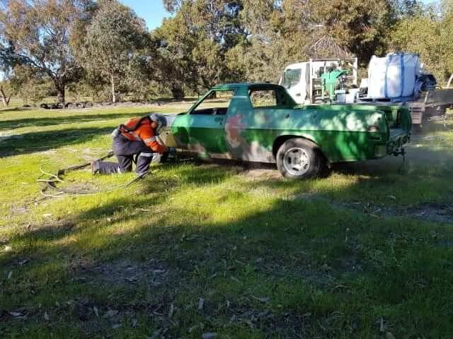 On-site car paint stripping with the rig parked alongside the vehicle