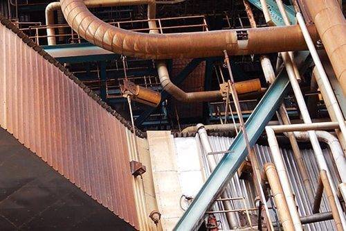 Pipework, coating removed Refinery pipework being abrasive blasted in Western Australia