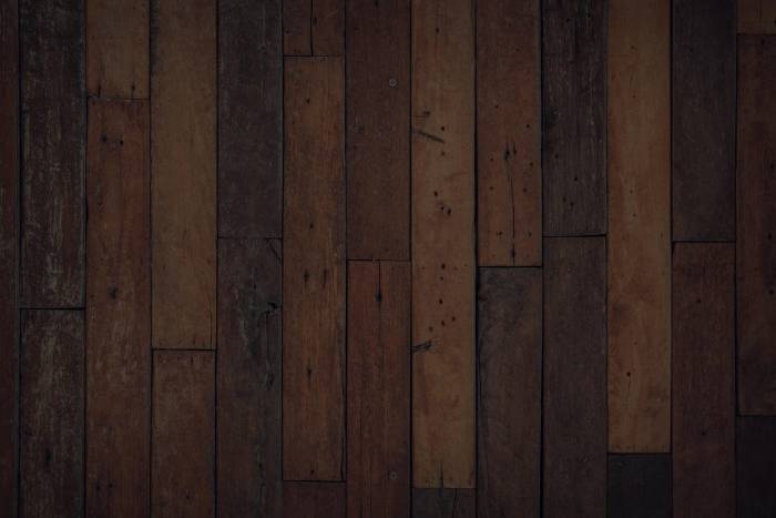 Jarrah beam half stripped of dark stain showing clean timber grain